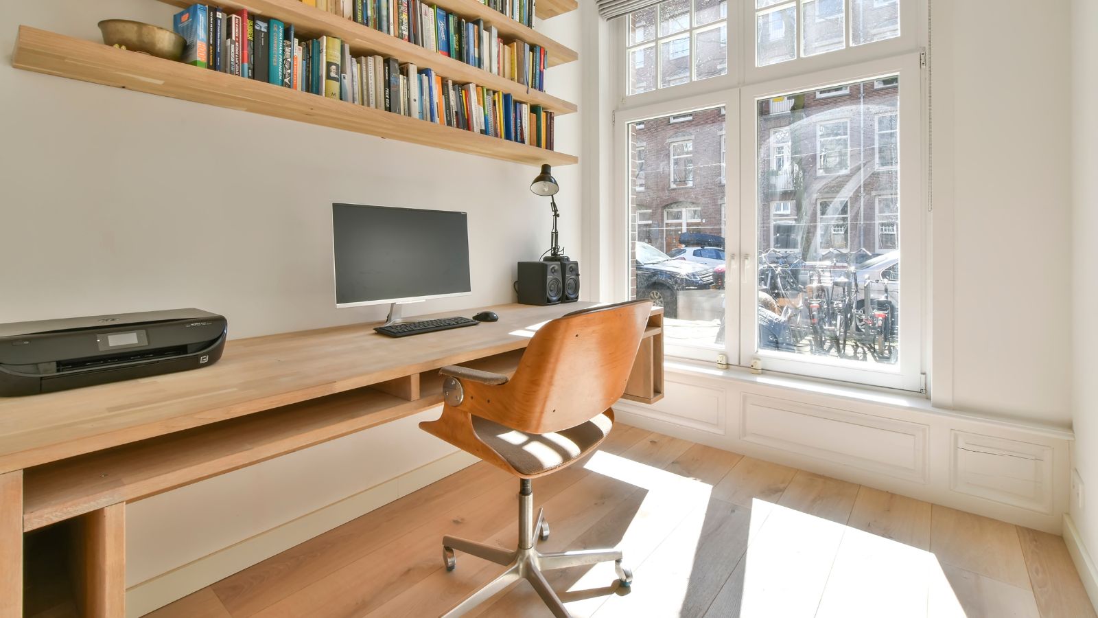A wall-mounted work desk and bookshelves in a home office