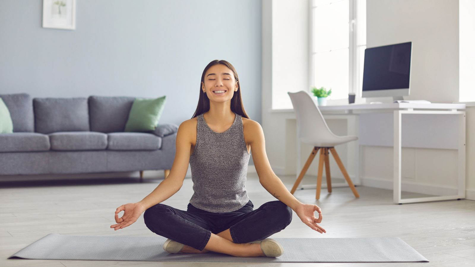 A young woman doing some yoga during a mini break at her home office